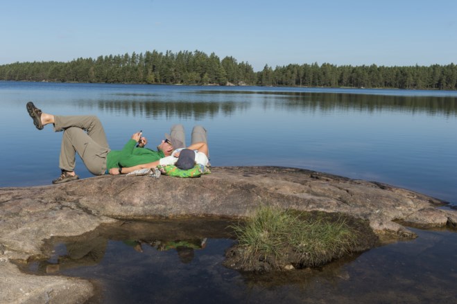 par som ligger på et svaberg med mobil